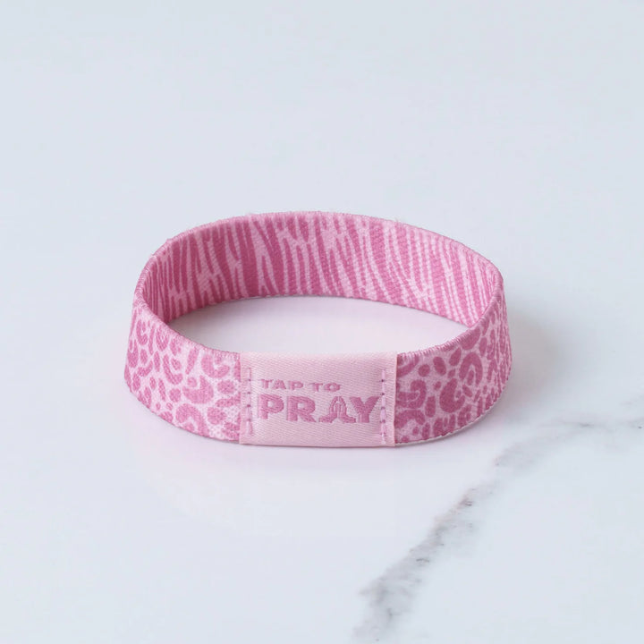 Pink wristband with text on a marble surface