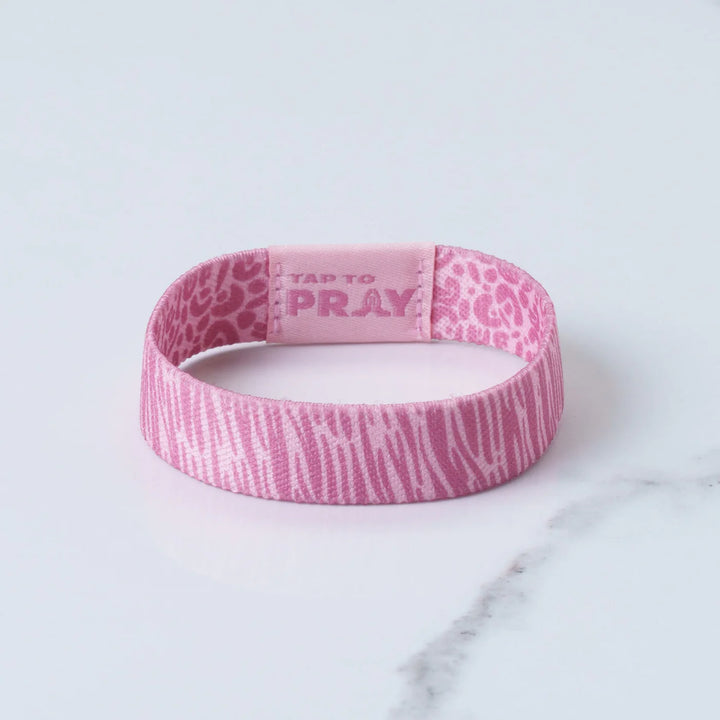 Pink wristband with text on a marble surface