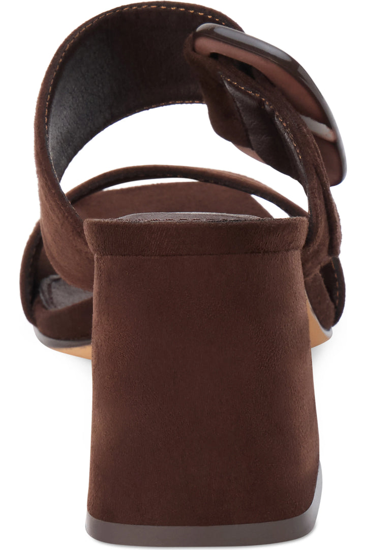 A close-up rear view of a brown suede block-heel sandal with a wide strap and a large dark brown oval buckle, shown on a white background.