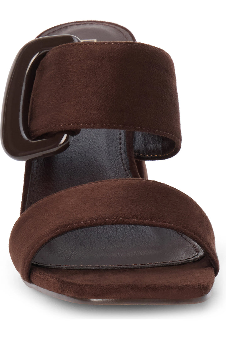 A dark brown suede slide sandal featuring a wide top strap with a large, glossy dark brown square buckle, a thick platform sole, and a low block heel, shown from a front-facing angle on a white background.