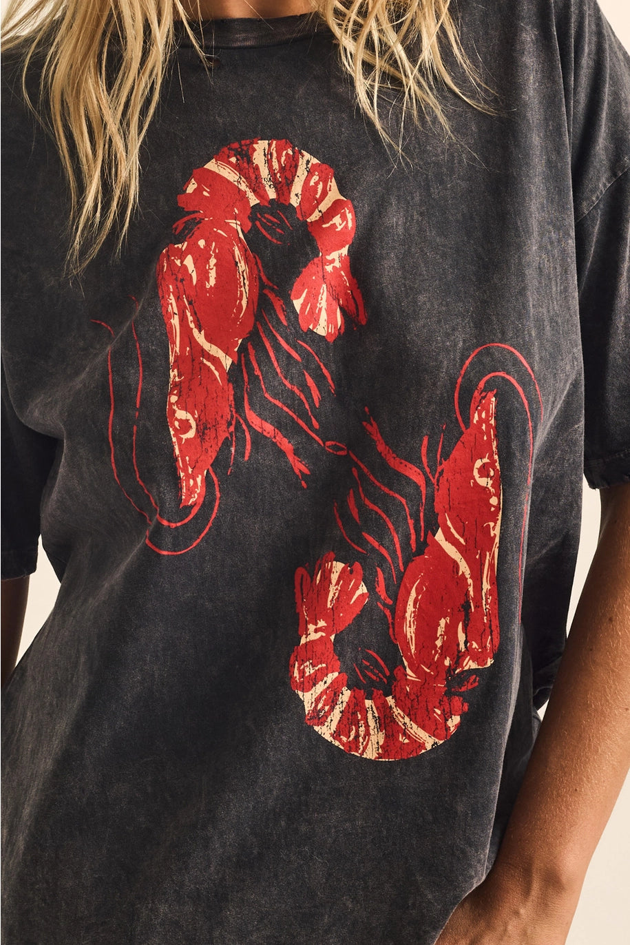 Black t-shirt with red shrimp design worn by a person