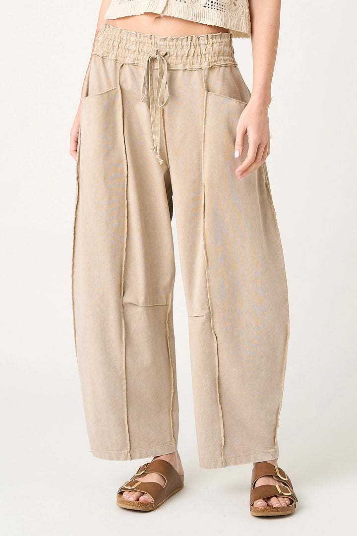 Beige wide-leg pants worn by a person on a white background