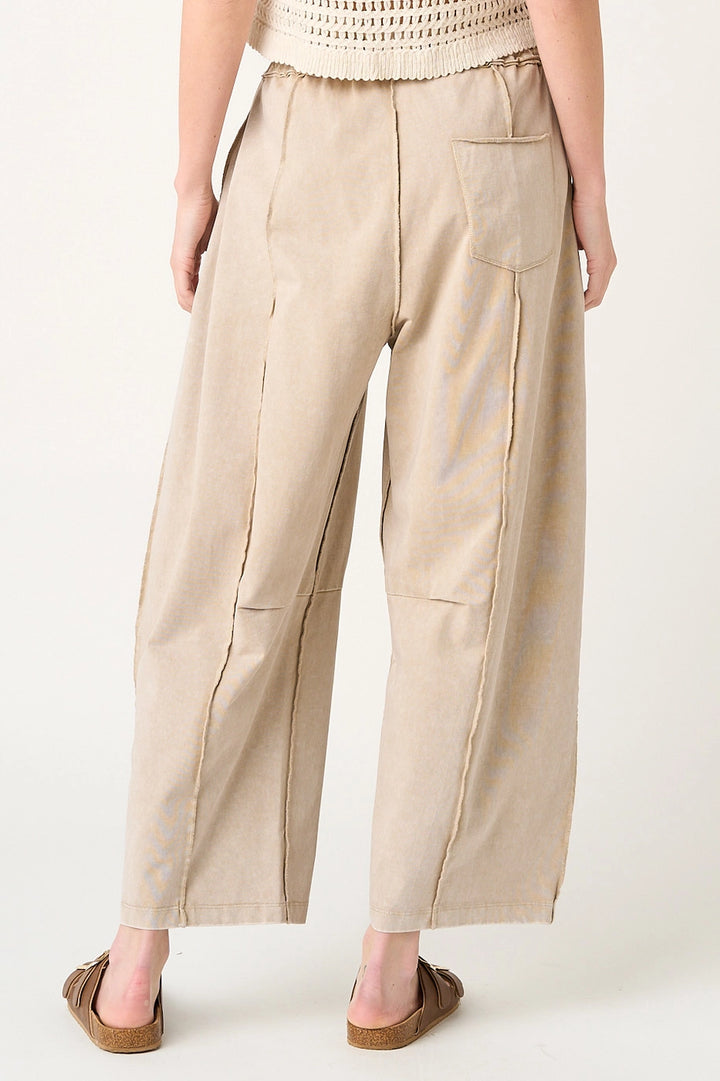 Beige wide-leg pants worn by a person on a white background