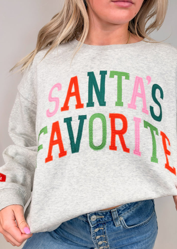 Woman wearing grey sweatshirt with &