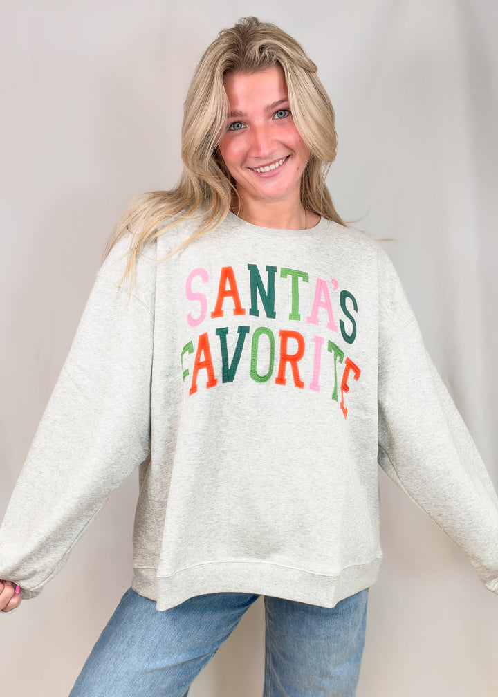 Woman wearing grey sweatshirt with &
