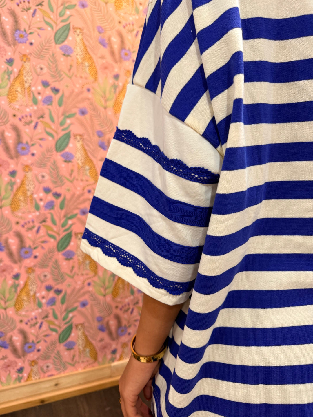 Close-up of blue and white striped fabric and a pink floral-patterned background