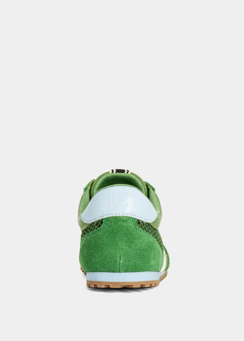 Green sneaker with white sole on a light gray background