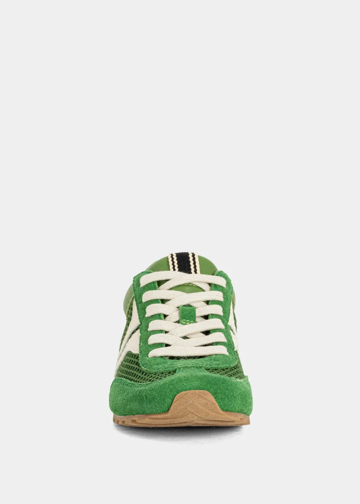 Green sneaker with white laces on a light gray background