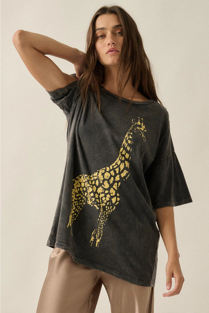 Woman wearing a dark gray t-shirt with a yellow giraffe design on a beige background