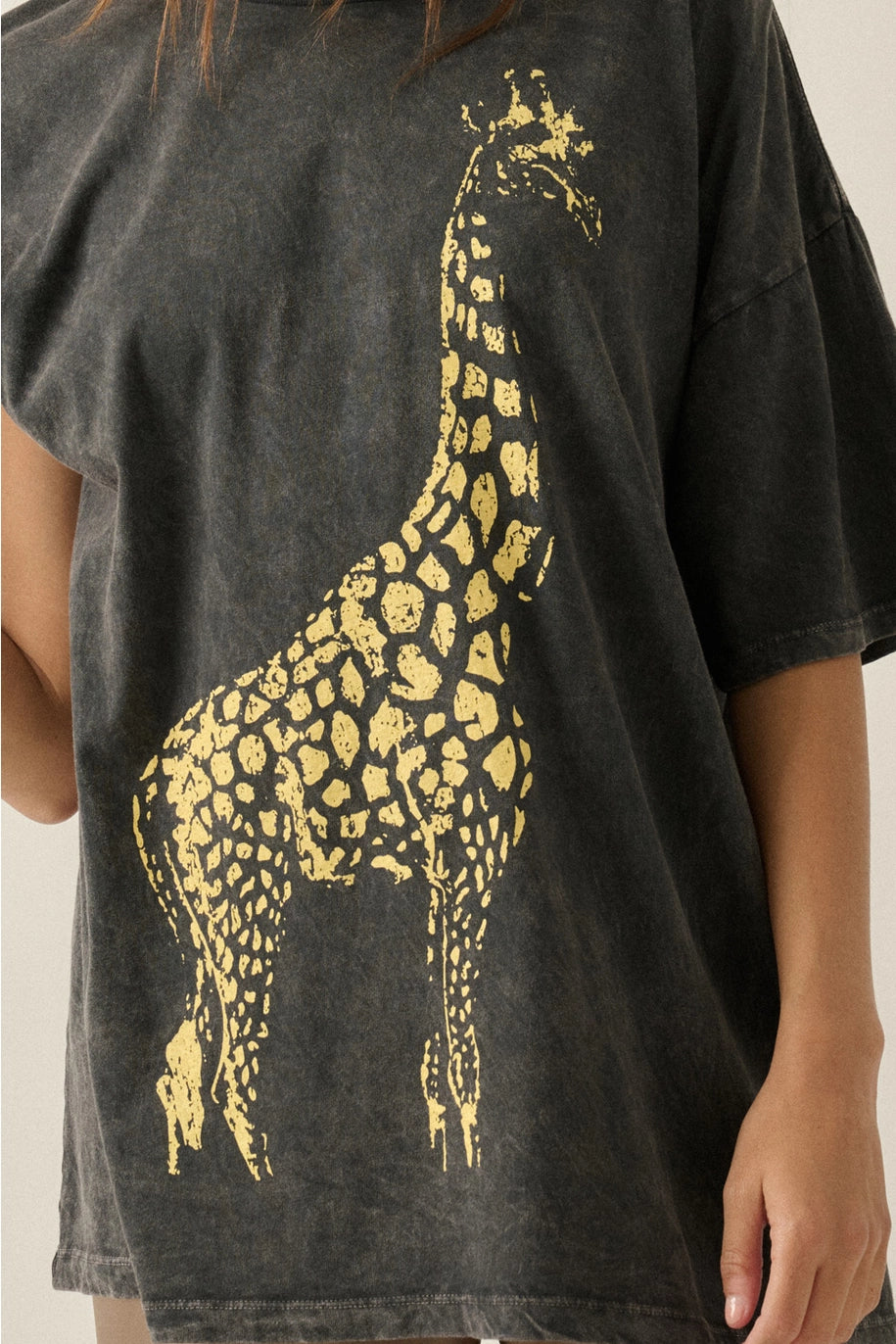 Black t-shirt with a gold giraffe design worn by a person.