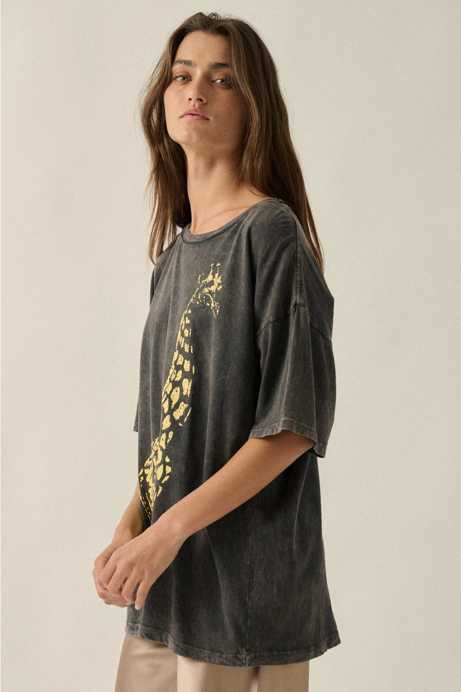Person wearing a dark gray t-shirt with a yellow graphic design on a beige background
