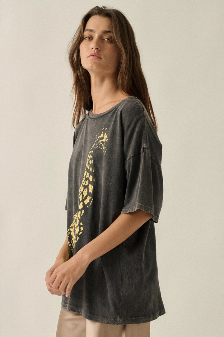 Person wearing a dark gray t-shirt with a yellow graphic design on a beige background