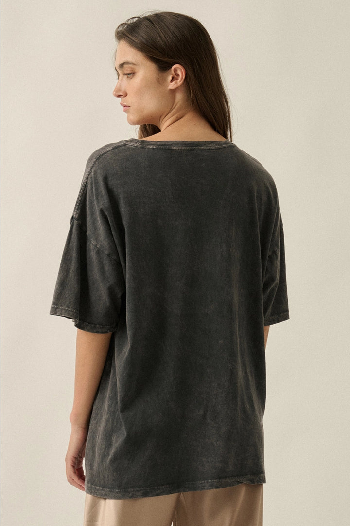 Woman wearing a black t-shirt against a beige background