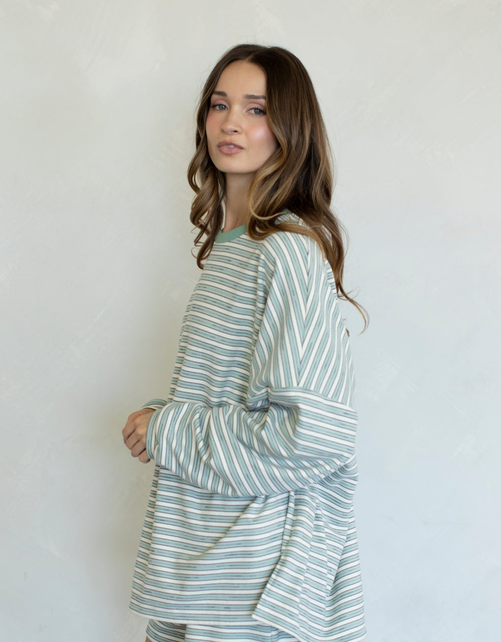 Woman wearing mint and white stripe set on plain background
