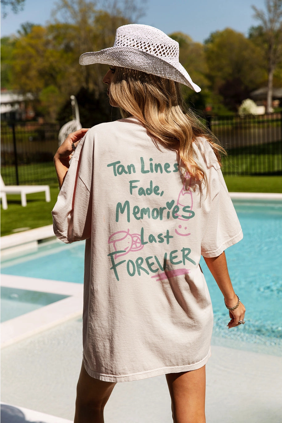 Back of woman wearing graphic tee with saying ' tan lines fade, memories last forever'