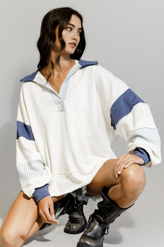 Woman wearing a white and blue striped sweater with a gray background