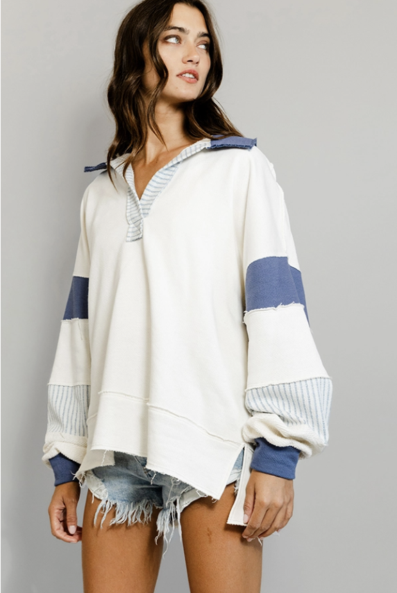 Woman wearing a white and blue striped sweater on a gray background