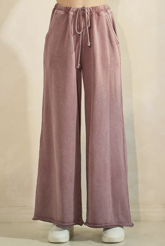 Pink wide-leg pants with drawstring waist on a beige background