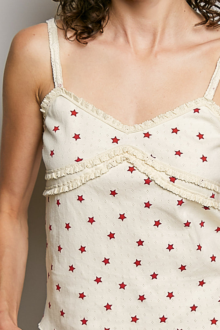 White sleeveless top with red star pattern worn by a person