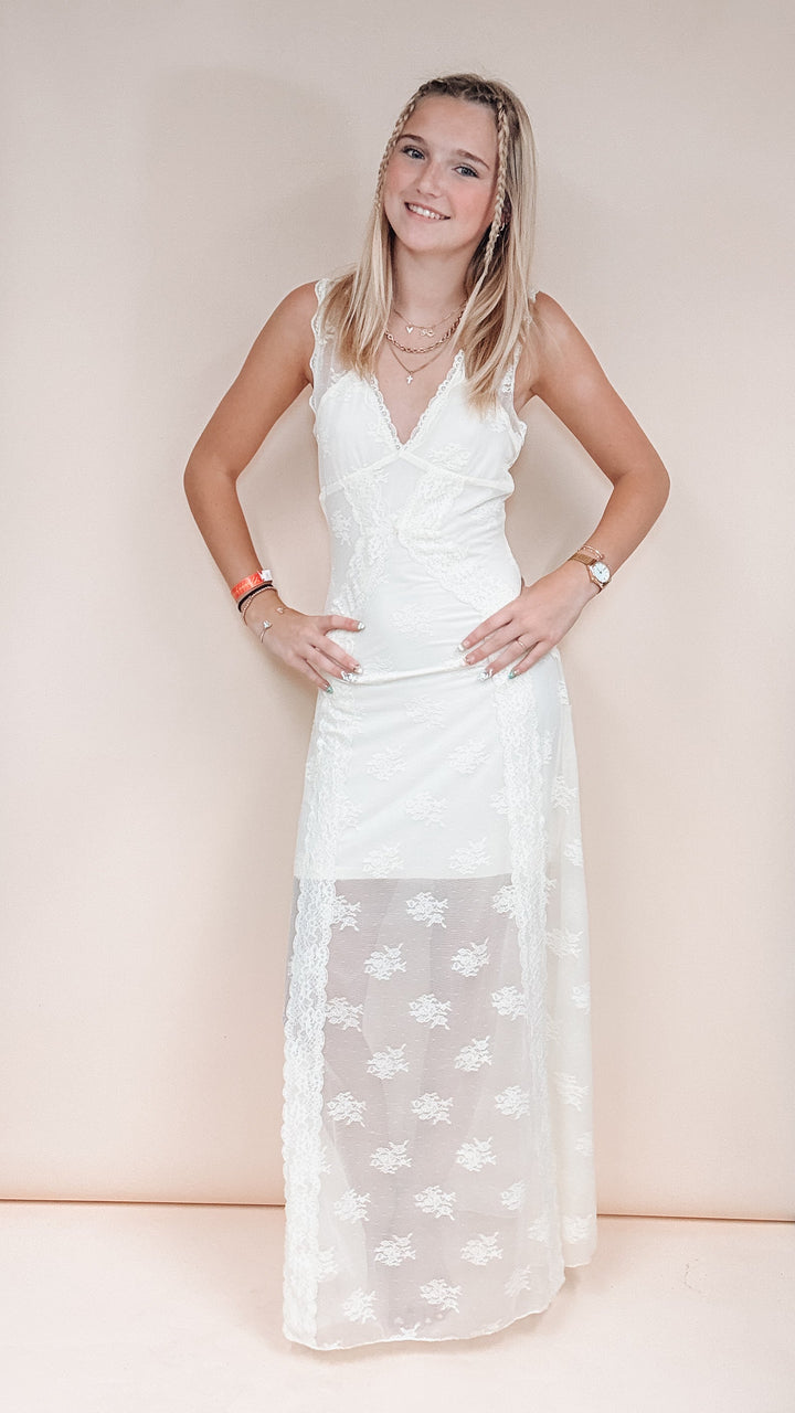 Woman wearing ivory lace overlay dress on plain background