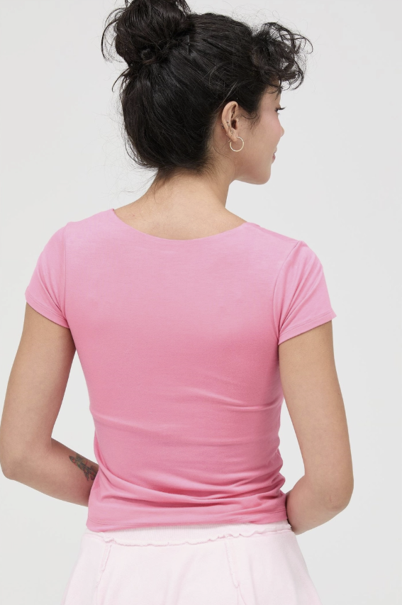 Person wearing a pink t-shirt against a white background
