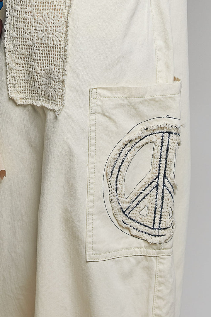 Close up of beige pants on plain background