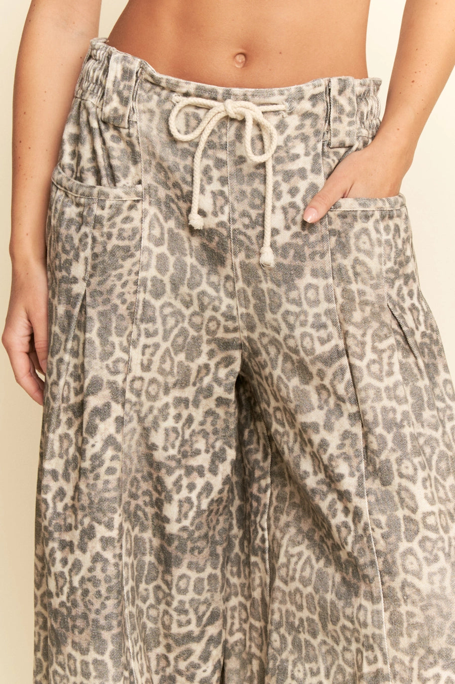 Leopard print pants with a drawstring waist on a plain background