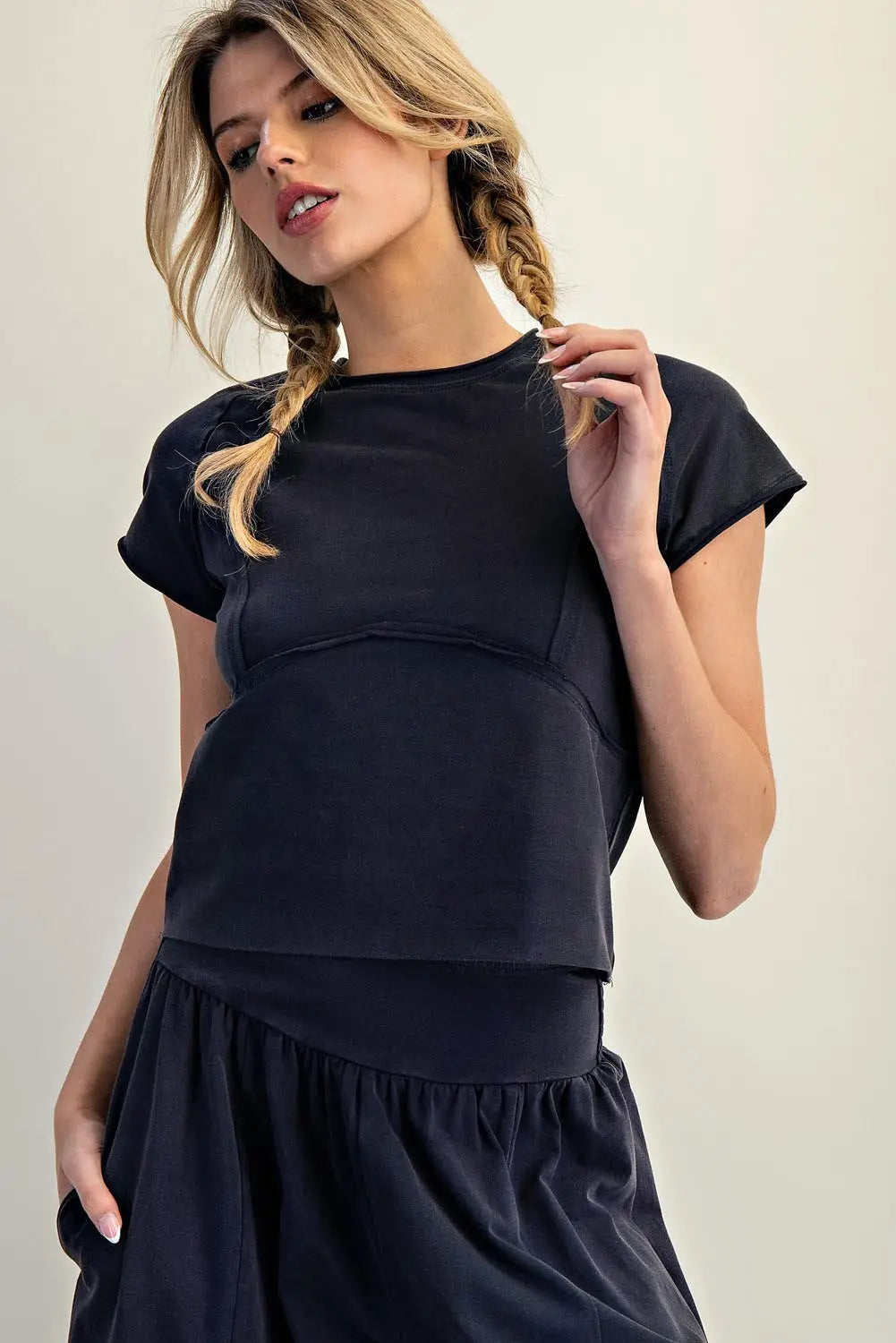 Woman wearing a black outfit against a plain background