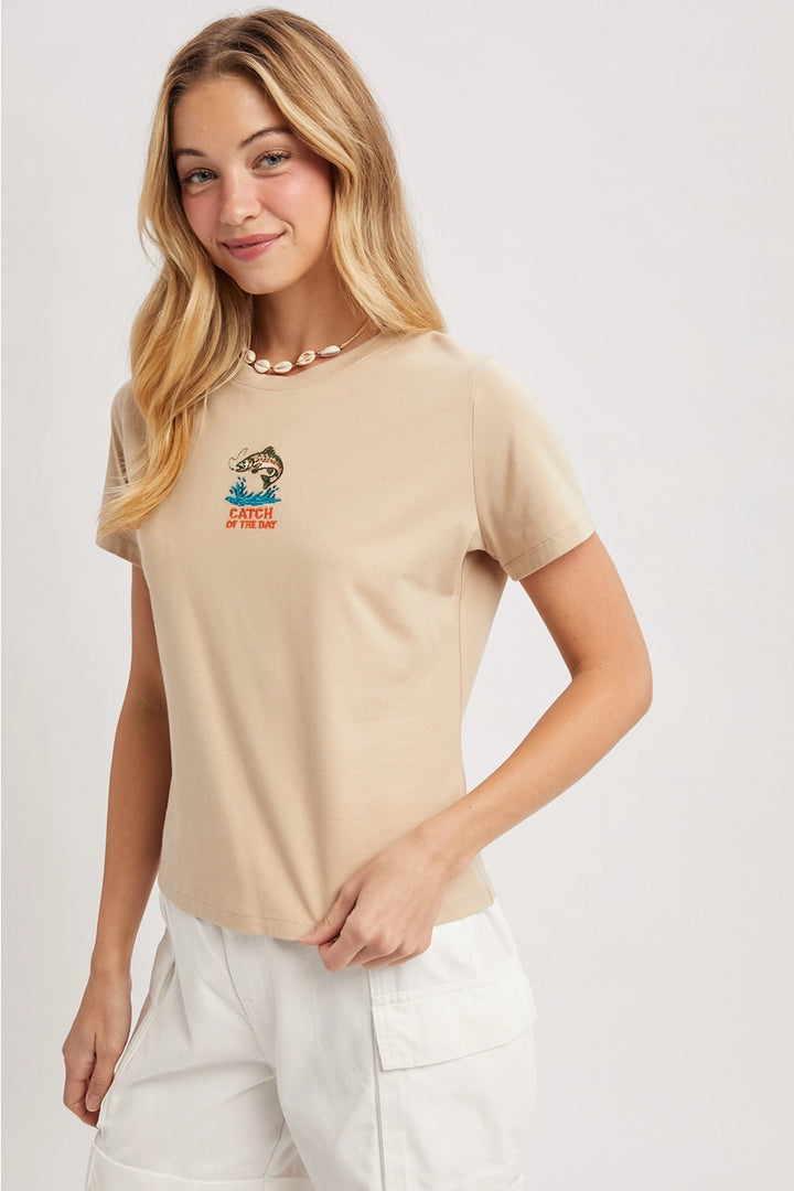 Woman wearing a beige t-shirt with a graphic design on a white background