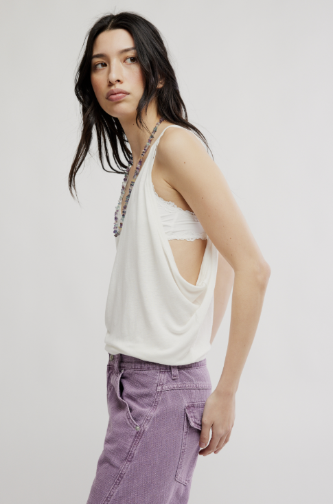 woman wearing white tank and purple pants on white background