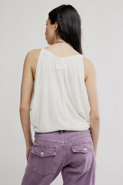 woman wearing white tank and purple pants on white background