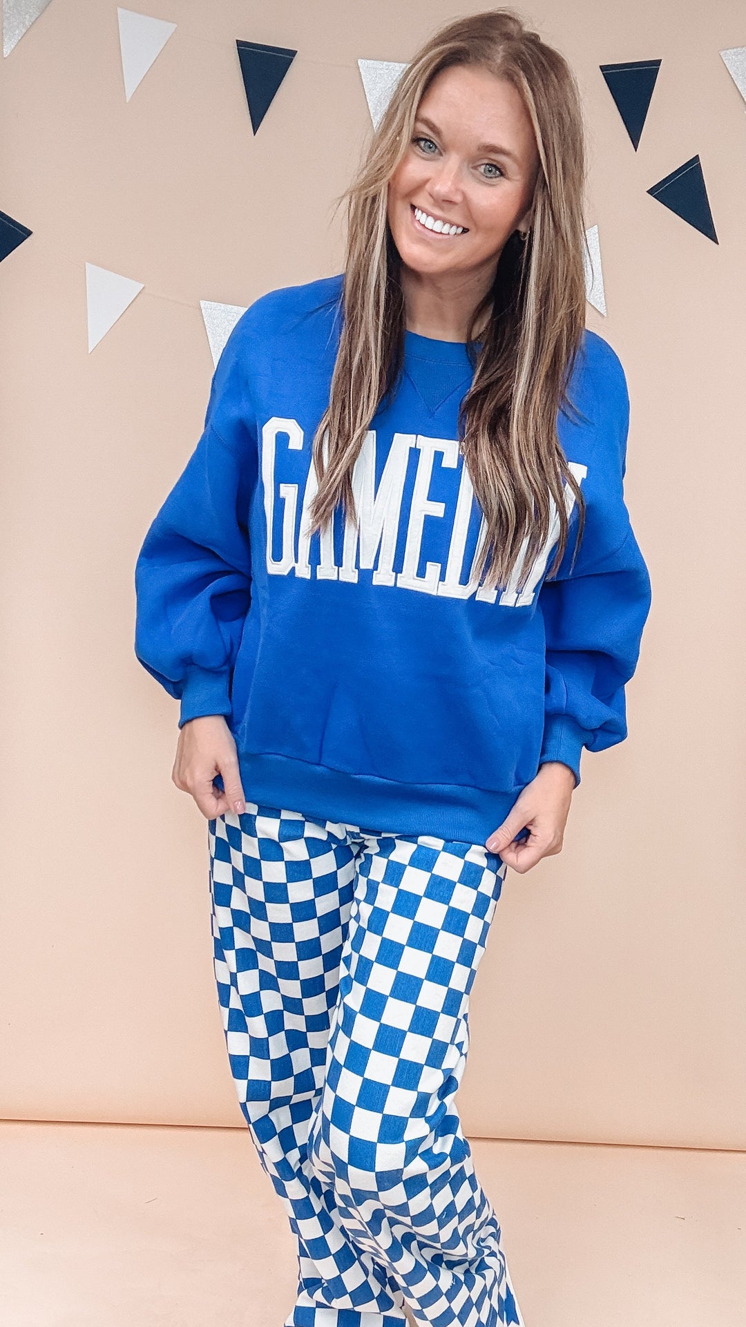 A woman modeling a bright blue sweatshirt with &