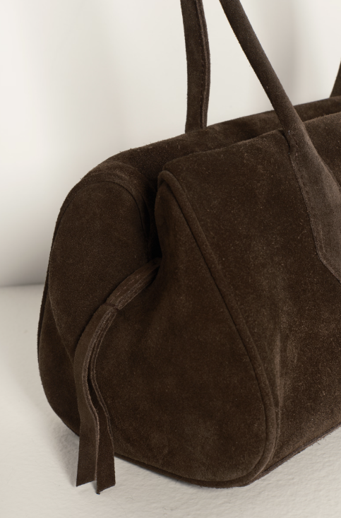 Brown suede handbag on a light background