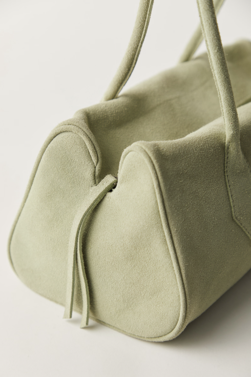 Light green handbag with handles on a light background