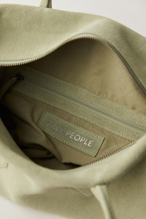 Close-up of a green bag with 'Free People' branding on a white background