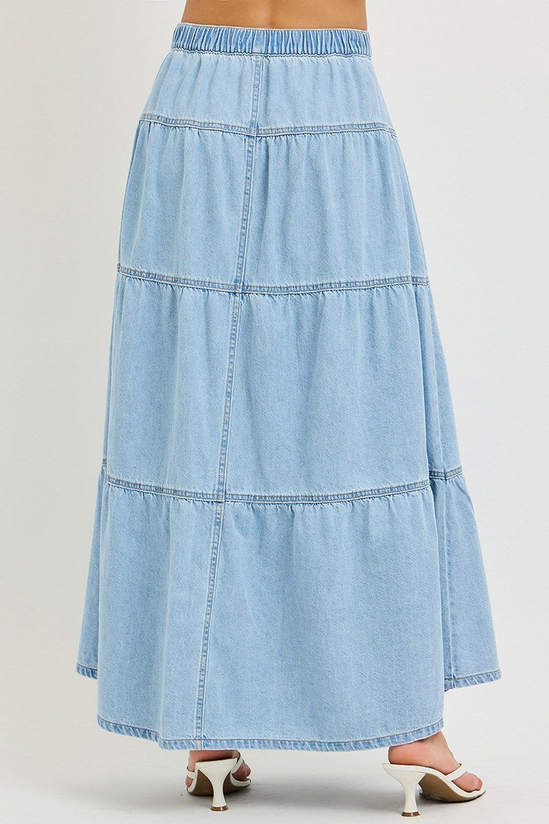 back of woman wearing denim maxi skirt on plain background