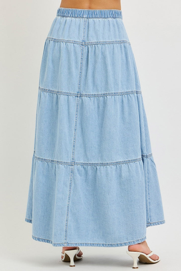 back of woman wearing denim maxi skirt on plain background