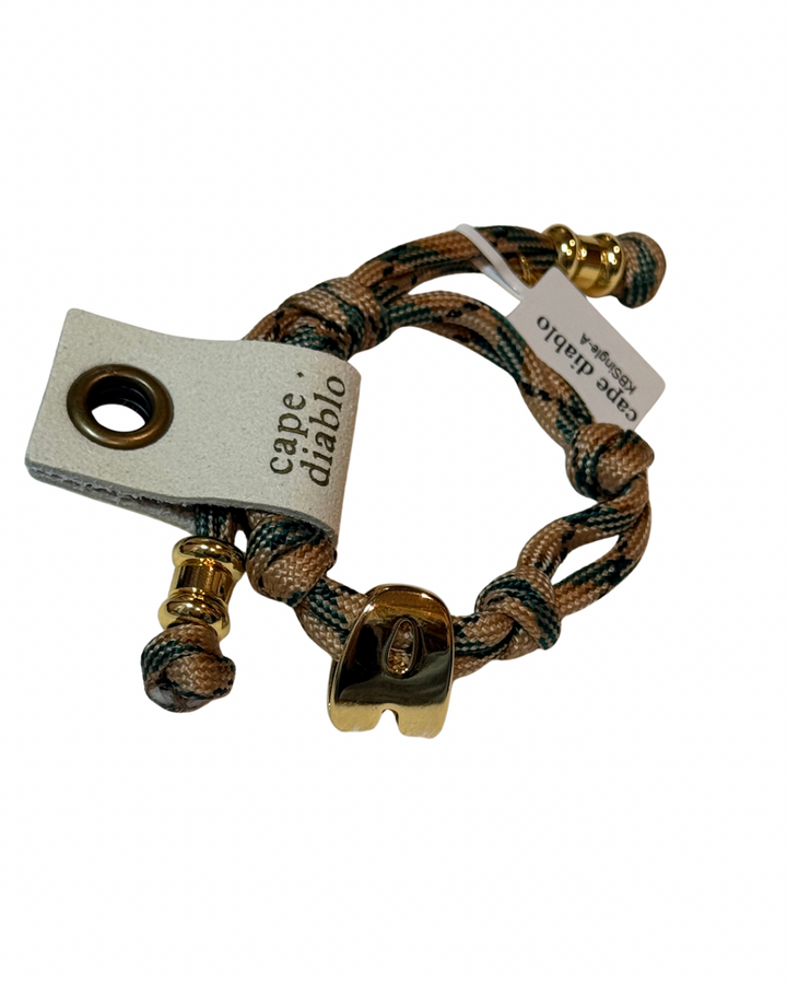 Cord Bracelet with gold accents on plain background