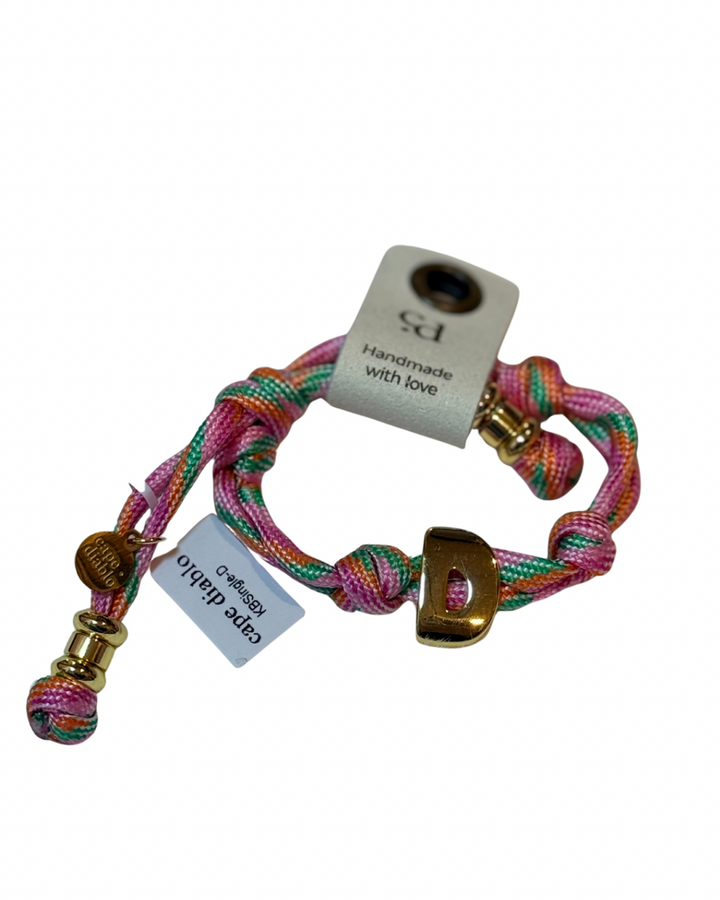 Cord bracelet with gold accents on plain background