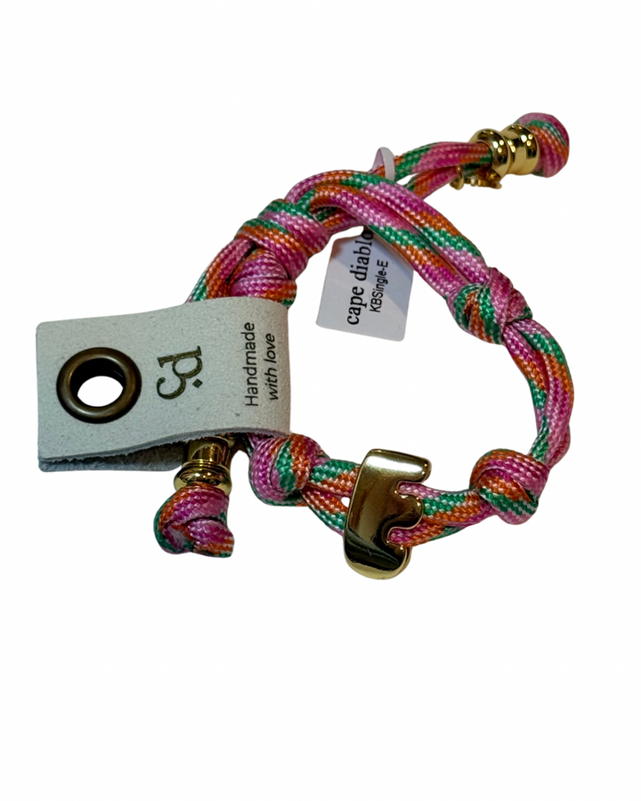 Cord bracelet with gold accents on plain background