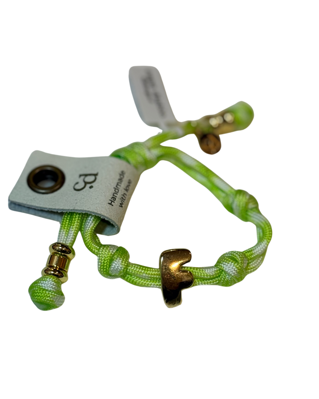 Cord bracelet with gold accents on plain background