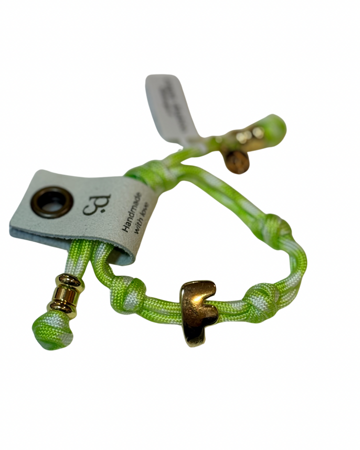 Cord bracelet with gold accents on plain background