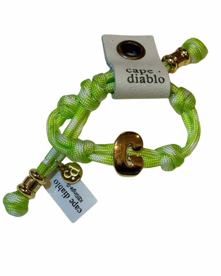 Cord bracelet with gold accents on plain background