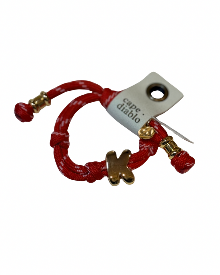 Red bracelet with gold accents on a white background, featuring a 'Cape Diablo' tag.
