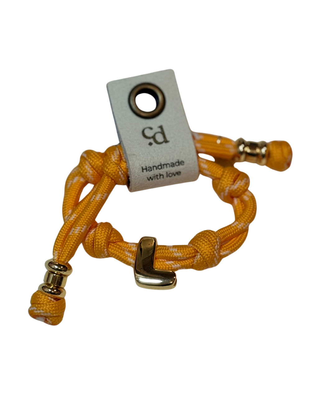 Cord bracelet with gold accents on plain background