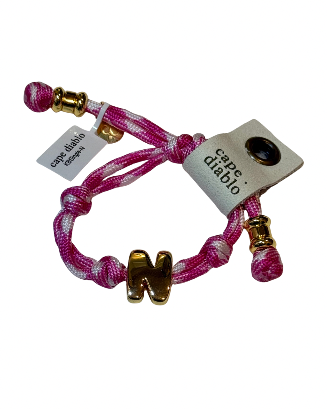 Pink and white braided bracelet with gold accents and 'cape diablo' tag on a white background