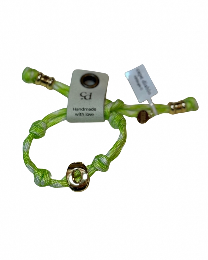 Cord bracelet with gold accents on plain background