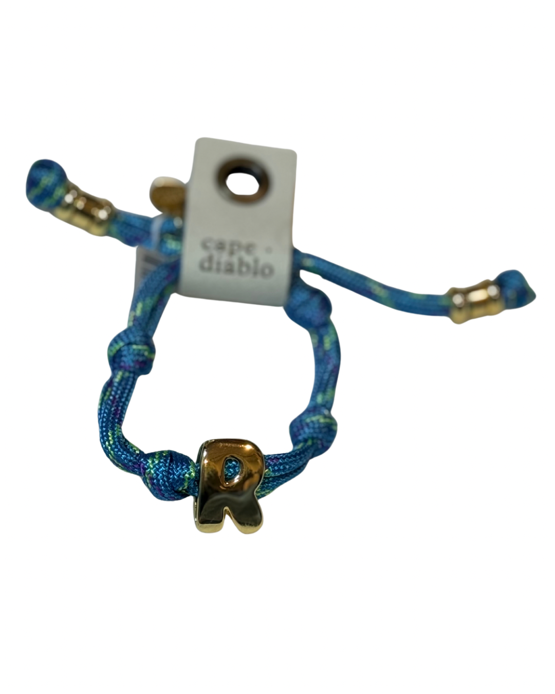 Cord bracelet with gold accents on plain background