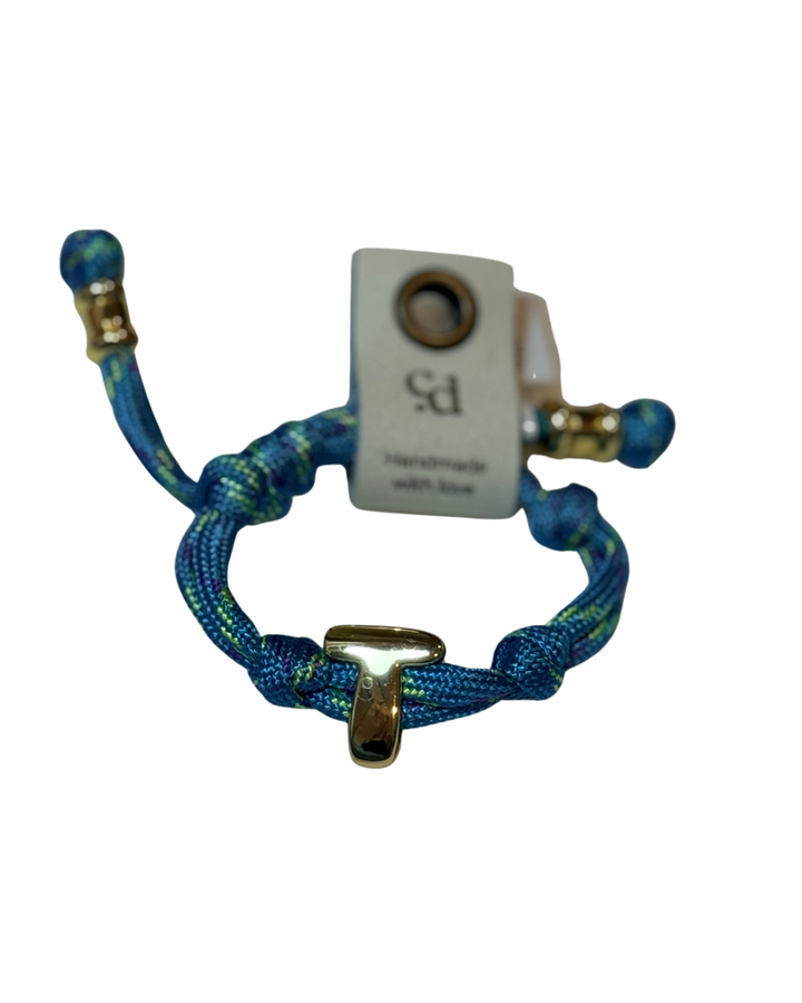 Cord bracelet with gold accents on plain background