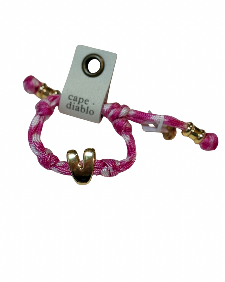 Cord bracelet with gold accents on plain background